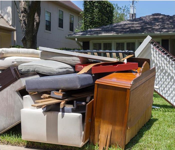 water damaged household furniture sitting outside on front lawn